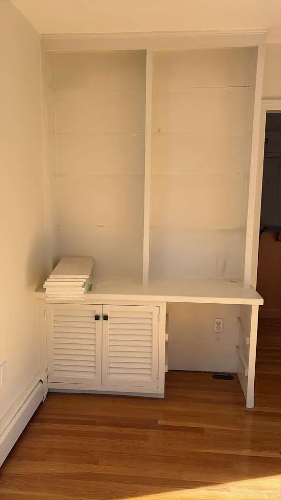 Built-in desk with louvered cabinets and floor-to-ceiling shelving in Sherborn, MA