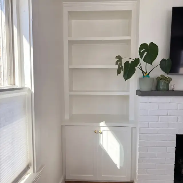 Built-in bookcase with lower cabinets beside a window in Beverly, MA