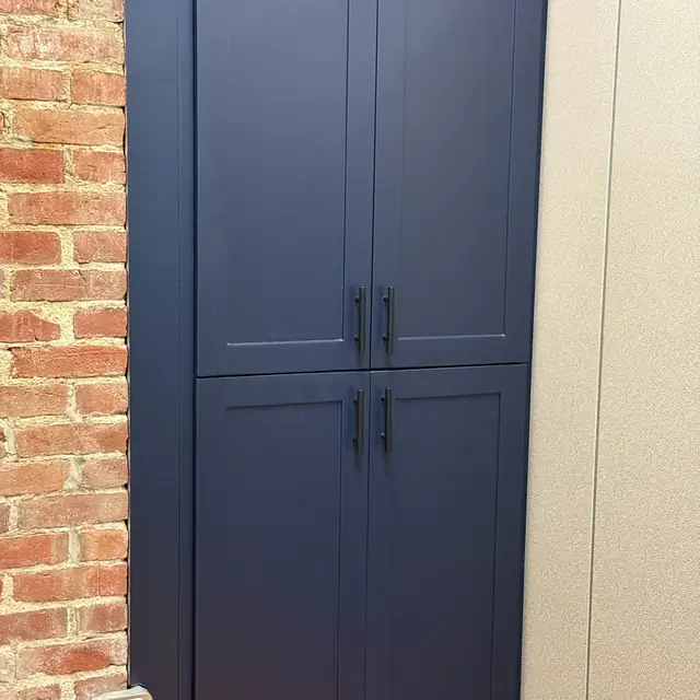 Navy blue built-in cabinets against exposed brick in Salem, MA